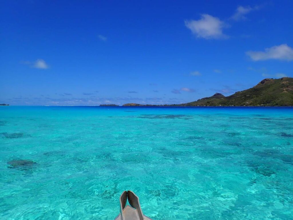 Laguna di Bora Bora con vegetazione sullo sfondo e orizzonte del mare