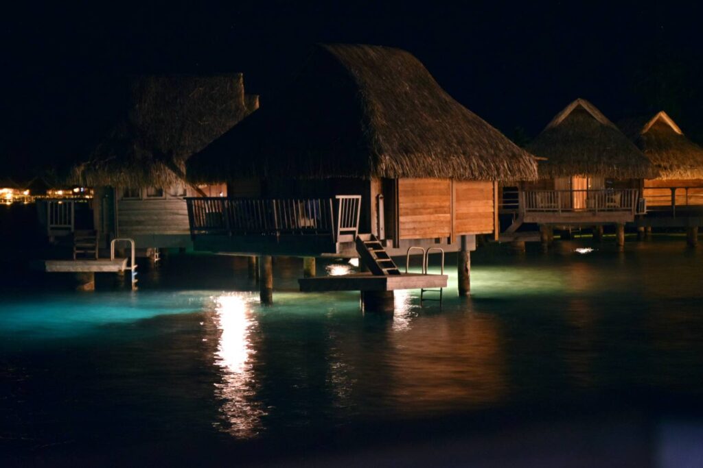 Bungalow overwater di Bora Bora visto di notte dalla nostra camera, illuminato dalle luci artificiali e circondato dalla laguna
