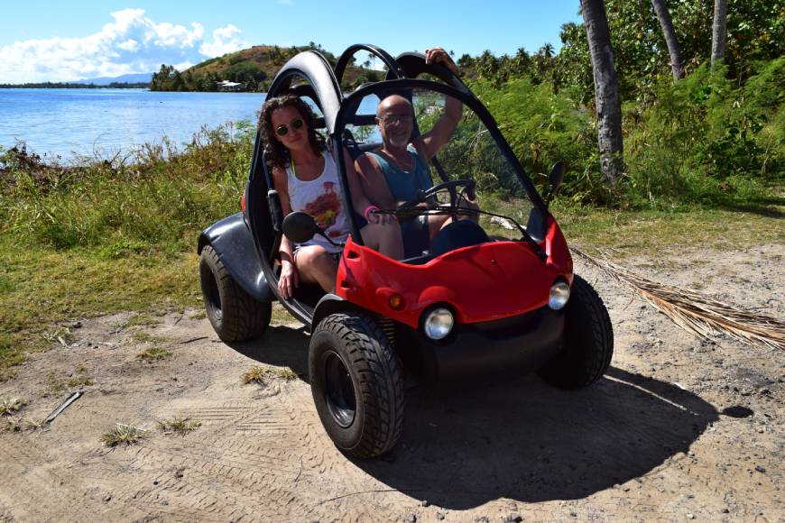 Coppia a bordo di una club car a Bora Bora, con la laguna visibile sullo sfondo