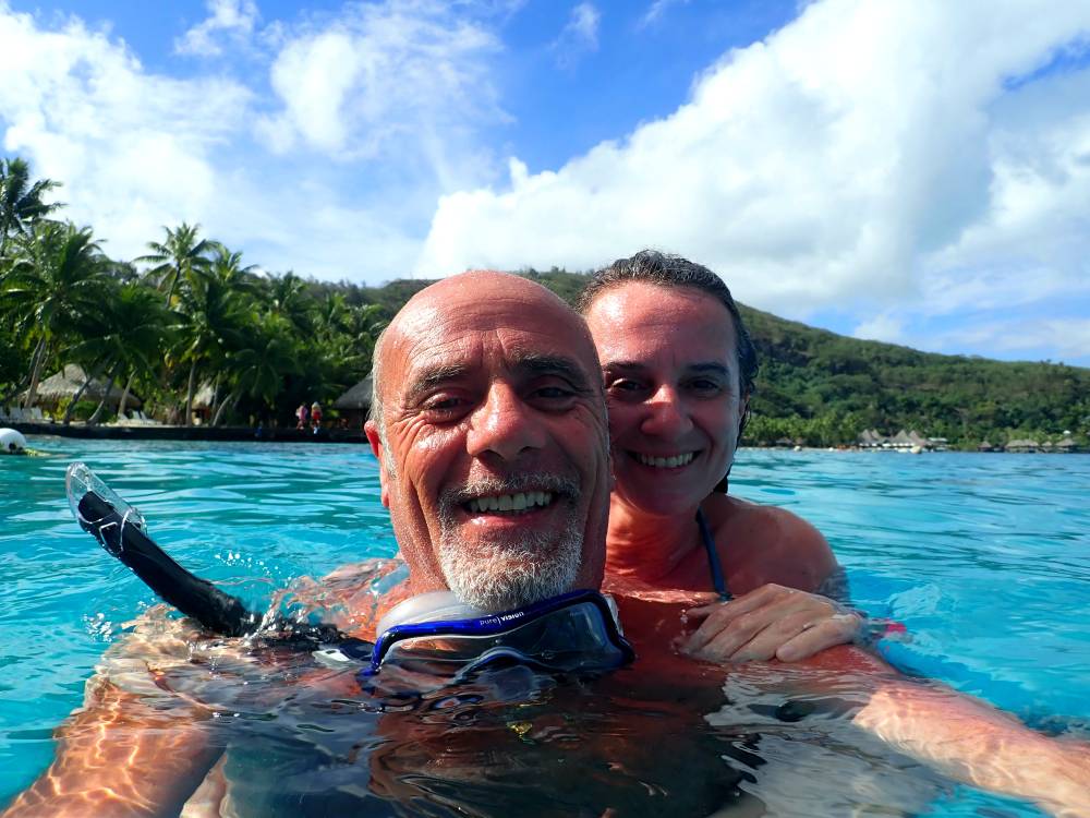 Coppia con maschera e boccaglio abbracciata nelle acque della laguna di Bora Bora durante lo snorkeling