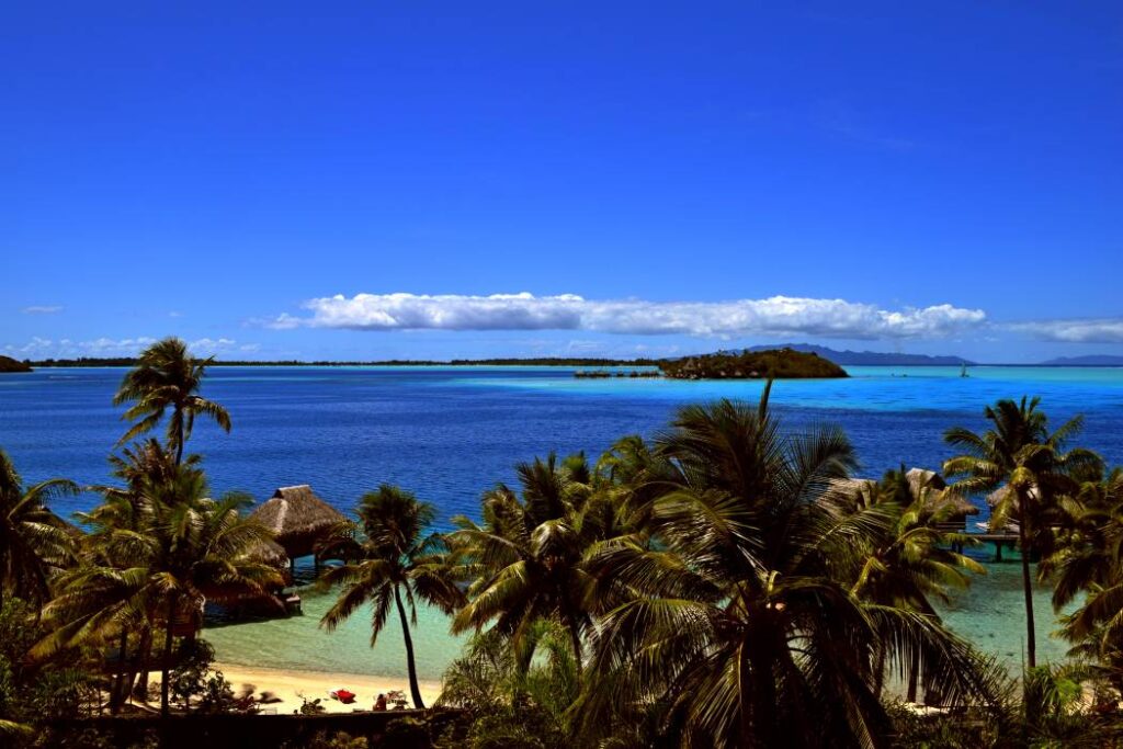 vista dalla camera sulla laguna di Bora Bora, con le diverse sfumature di blu dell’acqua, i bungalow overwater e le palme sullo sfondo